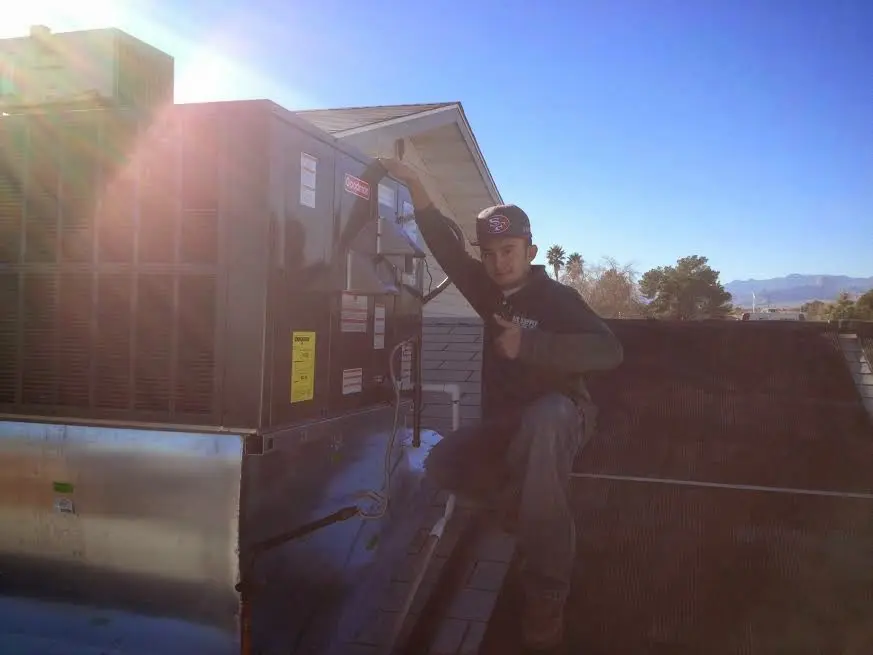 HVAC technician performing HVAC Inspection on a rooftop unit in Harahan